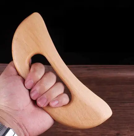 Gua sha board held in hand for scale